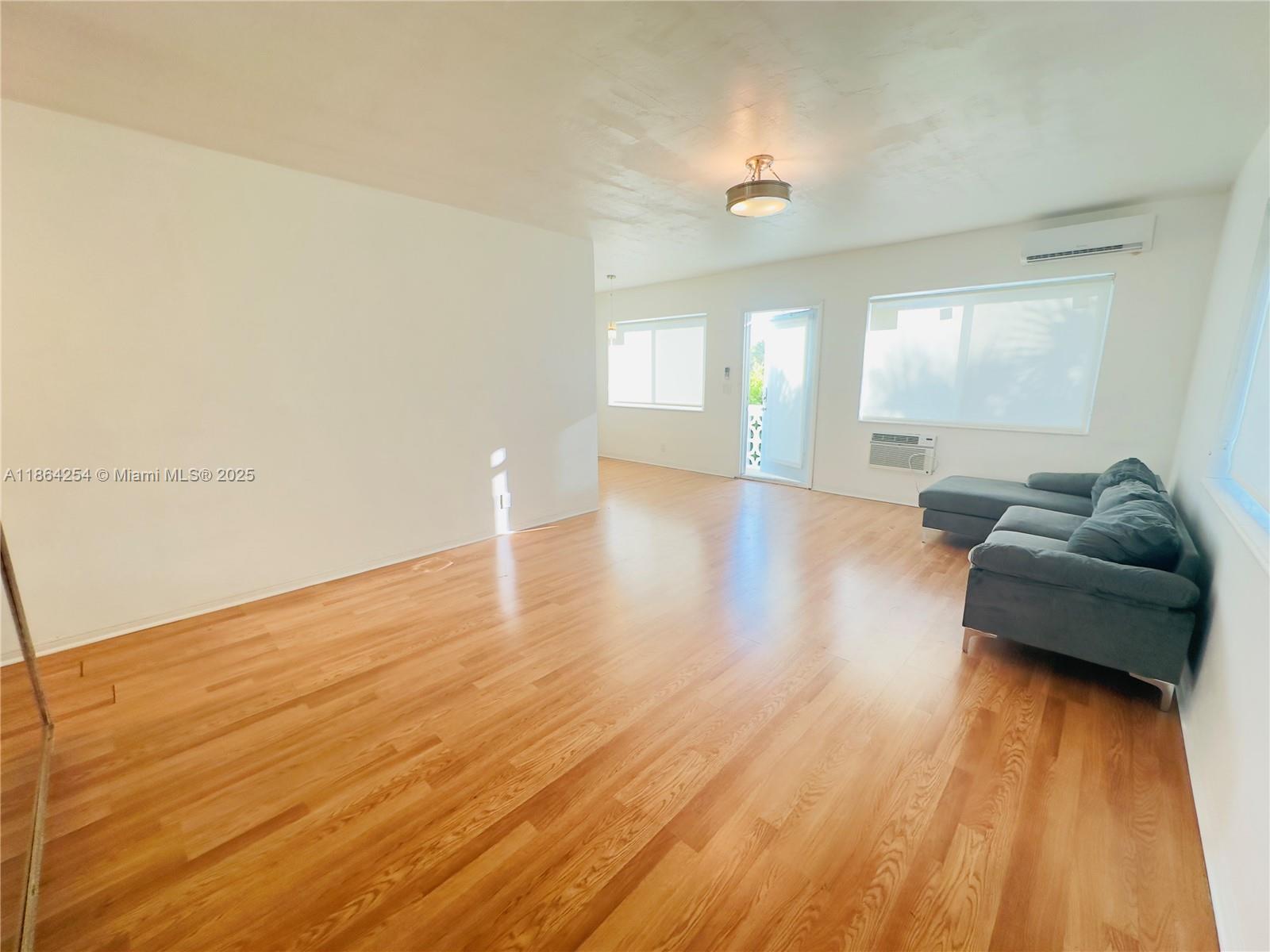 455 Golden Isles Drive, Unit 210 Hallandale Beach, FL 33009 - Photo 5 of 27 a view of empty room with wooden floor and fan