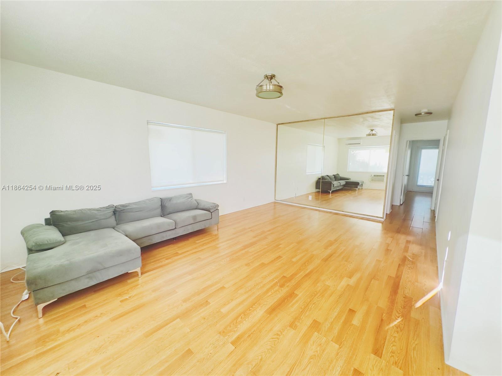 455 Golden Isles Drive, Unit 210 Hallandale Beach, FL 33009 - Photo 6 of 27 a living room with furniture and a flat screen tv