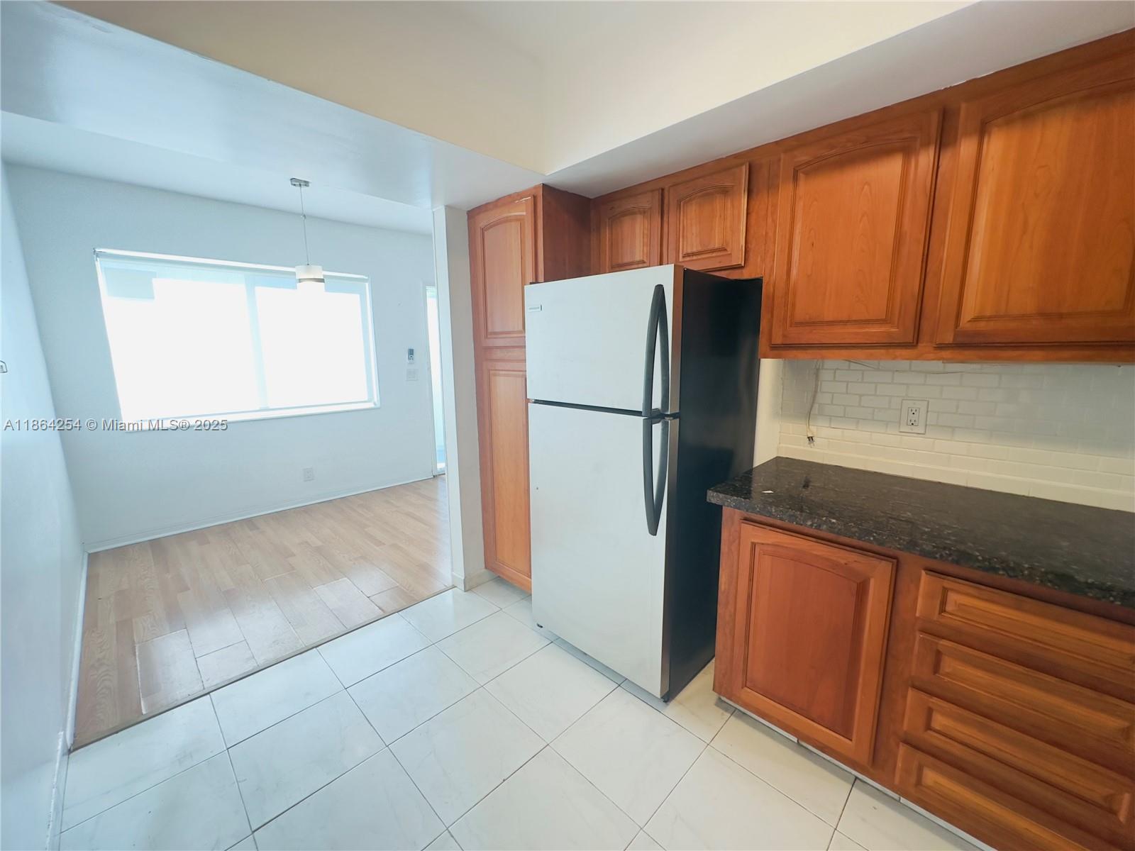 455 Golden Isles Drive, Unit 210 Hallandale Beach, FL 33009 - Photo 8 of 27 a white refrigerator freezer sitting in a kitchen