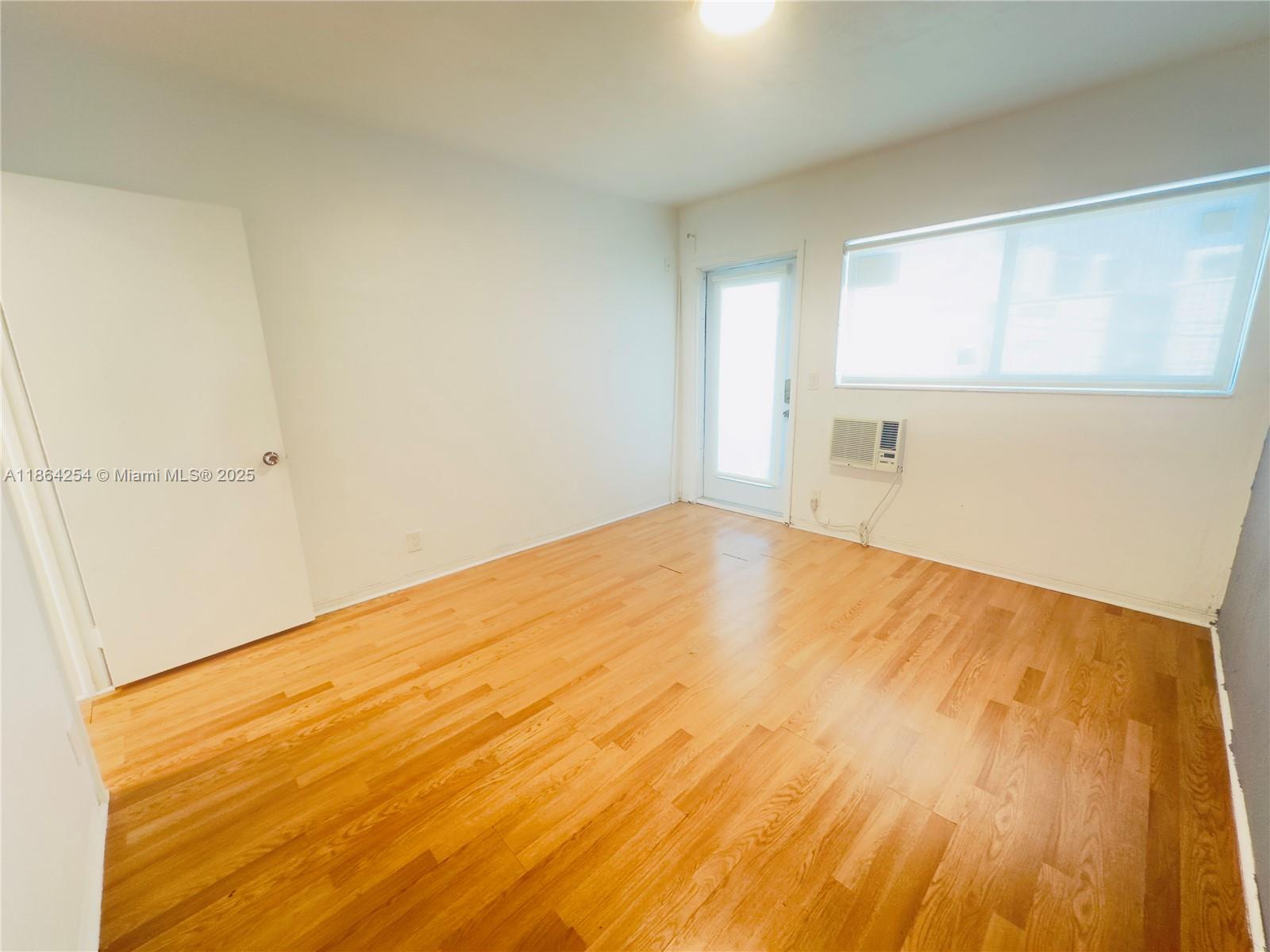455 Golden Isles Drive, Unit 210 Hallandale Beach, FL 33009 - Photo 9 of 27 a view of empty room with wooden floor and fan