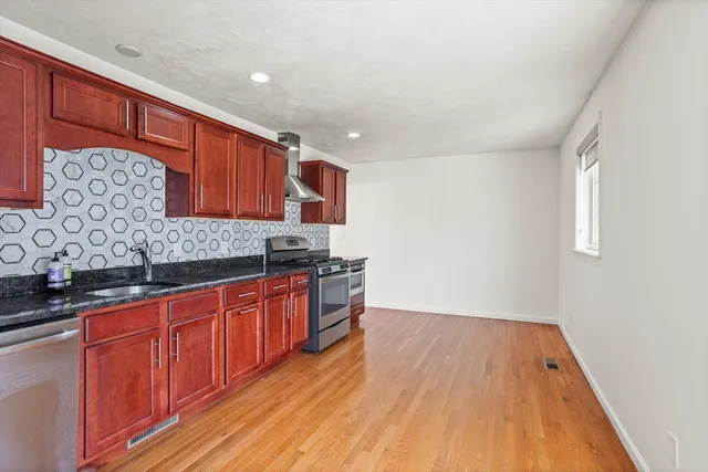 a kitchen with wooden floors and wooden cabinets