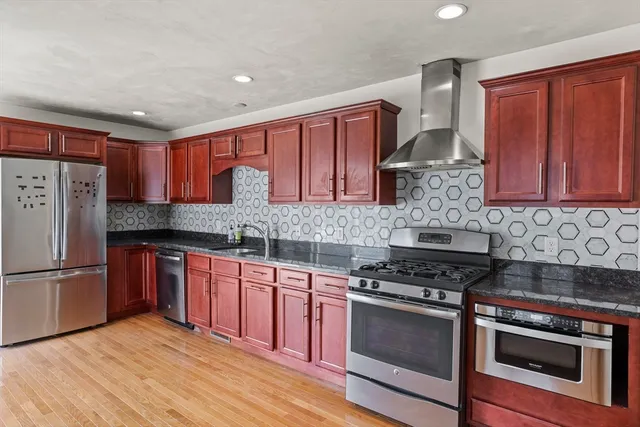 a kitchen with stainless steel appliances granite countertop a stove a sink dishwasher and a refrigerator