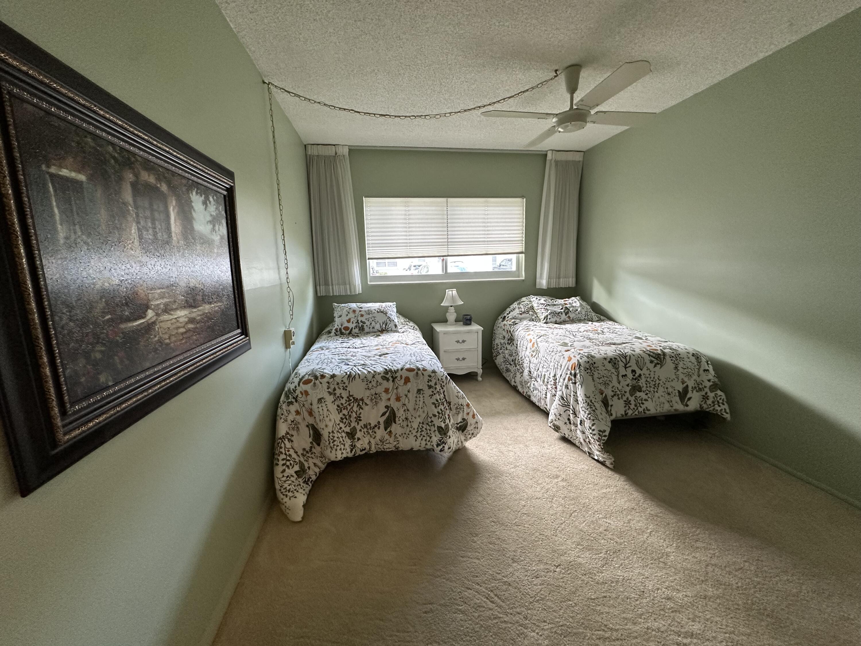 2320 Southwest 22nd Avenue, Unit 211 Delray Beach, FL 33445 - Photo 4 of 38 a bedroom with two beds and painting on the wall