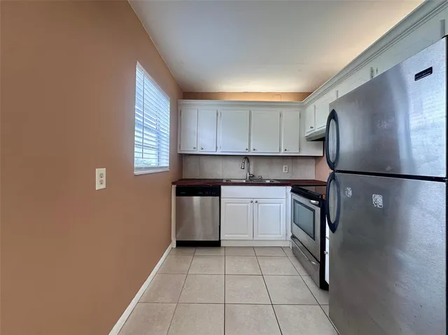 a kitchen with granite countertop a refrigerator and a stove top oven