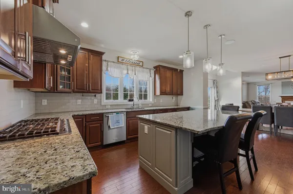a dining room with wooden floor a chandelier a wooden table and chairs