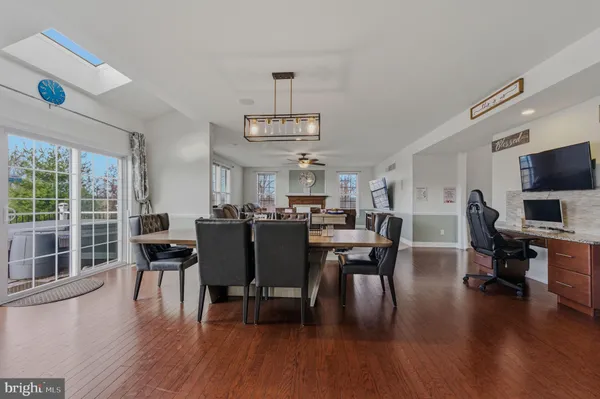 a kitchen with stainless steel appliances granite countertop a sink a stove a refrigerator cabinets and wooden floor