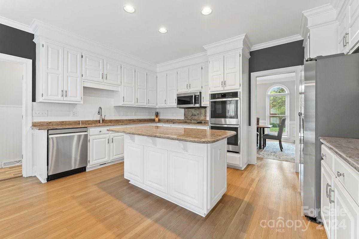 4527 Nora's Path Road Charlotte, NC 28226 - Photo 16 of 39 a kitchen with kitchen island granite countertop a sink cabinets and stainless steel appliances