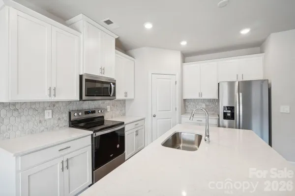 a kitchen with a sink a refrigerator and cabinets