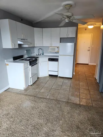 a kitchen with a sink a stove a refrigerator and cabinets