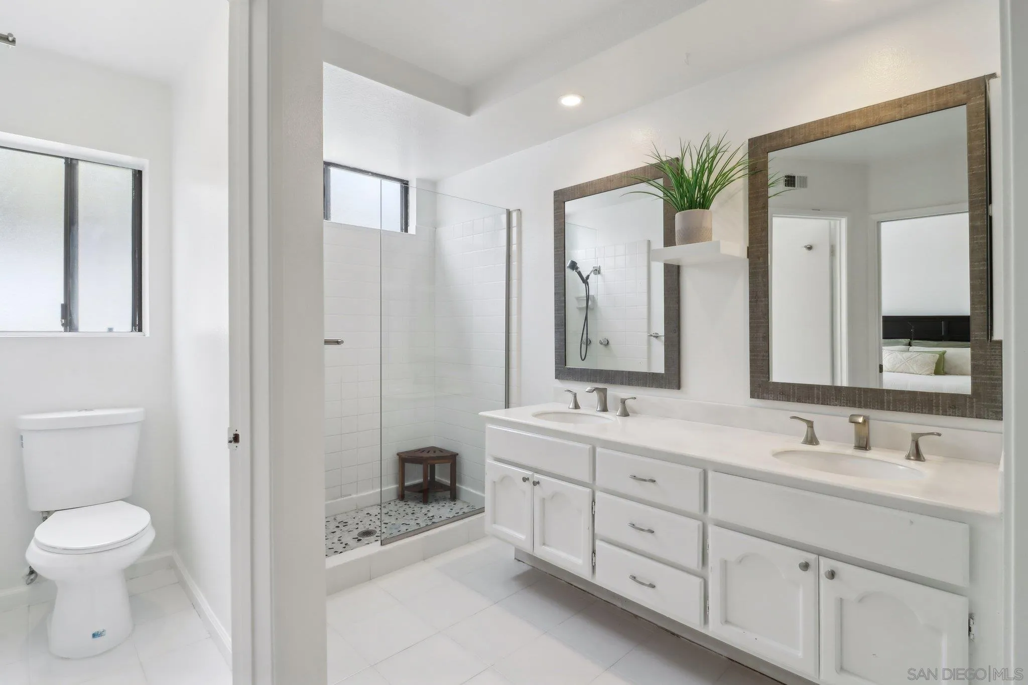 6872 Shearwaters Drive Carlsbad, CA 92011 - Photo 15 of 45 a bathroom with a toilet a double vanity sink and a mirror