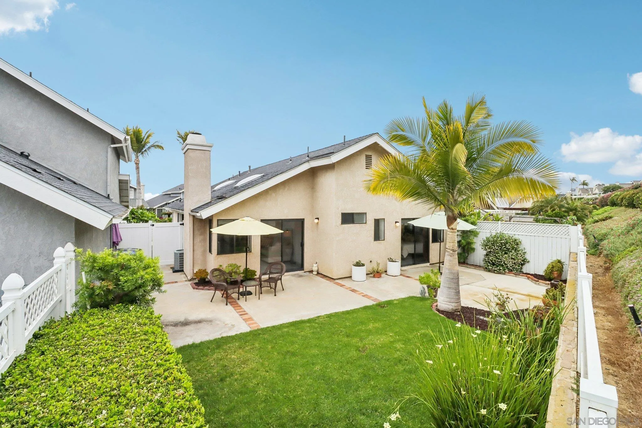 6872 Shearwaters Drive Carlsbad, CA 92011 - Photo 30 of 45 a view of a patio with table and chairs potted plants with wooden fence