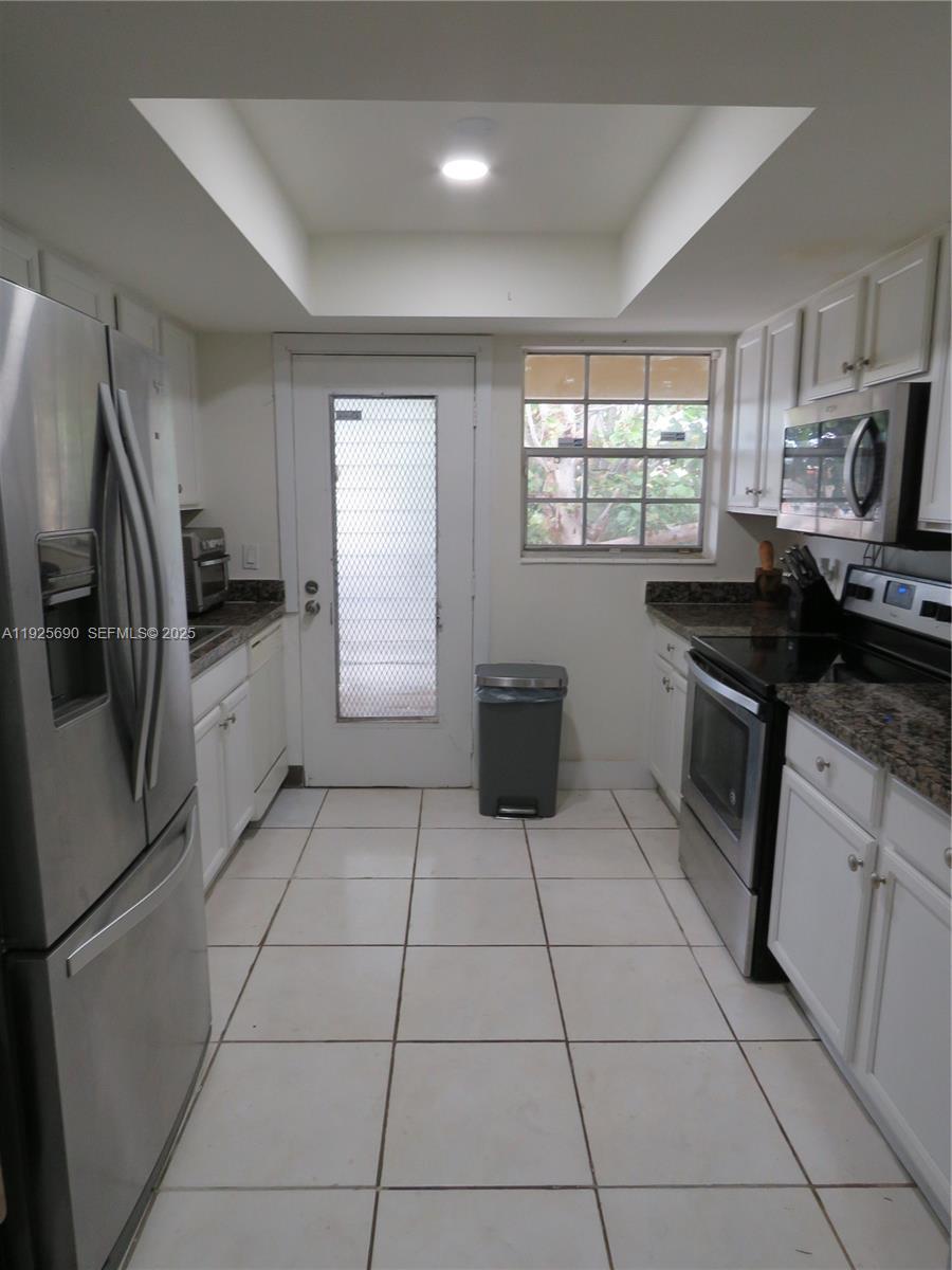 11840 Northeast 19th Drive, Unit 26 North Miami, FL 33181 - Photo 5 of 15 a kitchen with stainless steel appliances granite countertop a stove a sink and a refrigerator