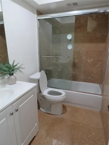 a white toilet sitting next to a bathroom sink