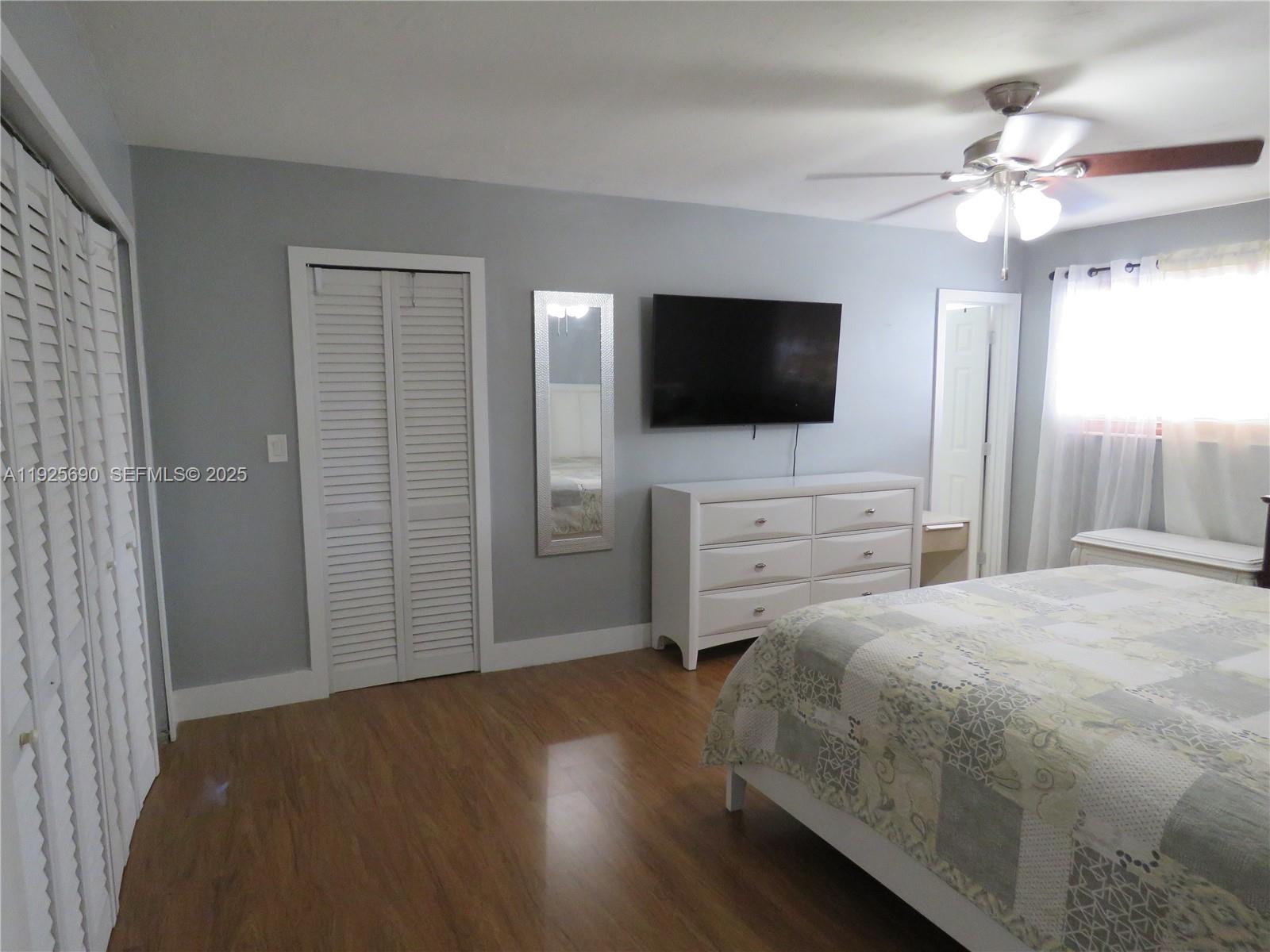 11840 Northeast 19th Drive, Unit 26 North Miami, FL 33181 - Photo 9 of 15 a bedroom with a bed and a flat screen tv