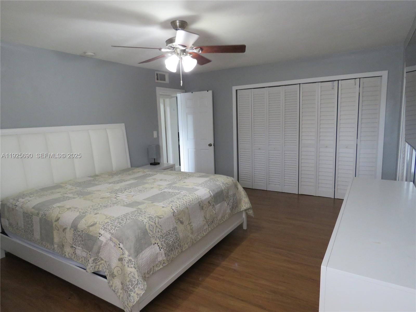 11840 Northeast 19th Drive, Unit 26 North Miami, FL 33181 - Photo 10 of 15 a bedroom with a bed and a chandelier