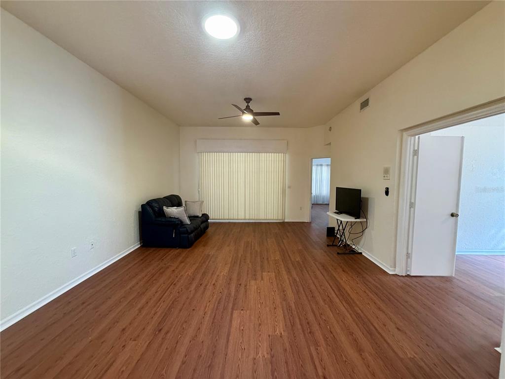 8037 Southwest 115th Loop Ocala, FL 34481 - Photo 19 of 47 a big room with wooden floor and windows