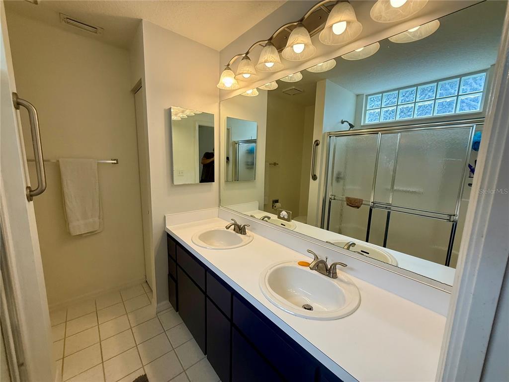 8037 Southwest 115th Loop Ocala, FL 34481 - Photo 25 of 47 a bathroom with a double vanity sink mirror and shower