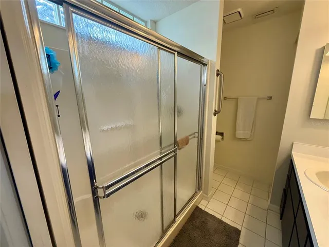 a bathroom with a glass door shower and a sink