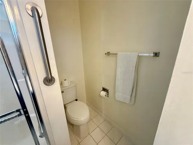 a bathroom with a granite countertop toilet and a shower