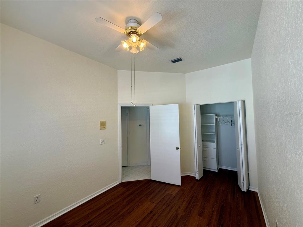 8037 Southwest 115th Loop Ocala, FL 34481 - Photo 34 of 47 an empty room with wooden floor and a ceiling fan