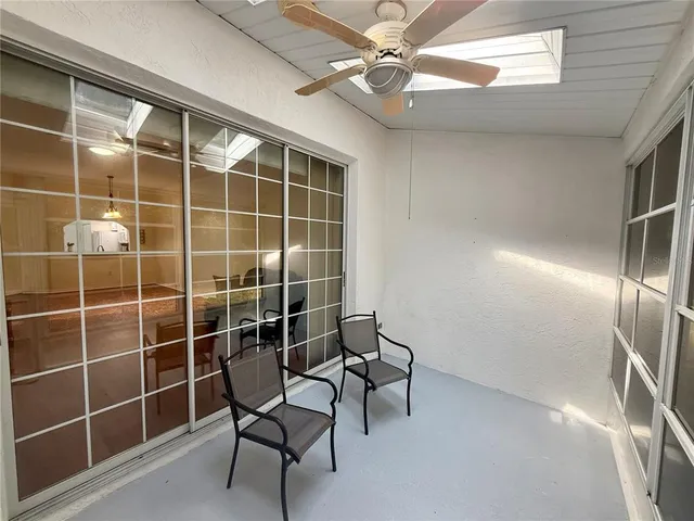 a view of a livingroom with wooden floor and a ceiling fan
