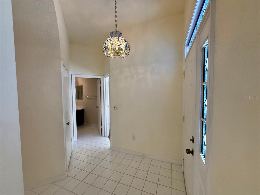 8037 Southwest 115th Loop Ocala, FL 34481 - Photo 6 of 47 a view of a hallway with chandelier and glass door