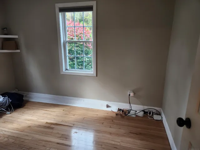 a room with window and hardwood floor