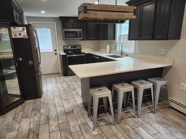 a kitchen with stainless steel appliances a table chairs and a refrigerator