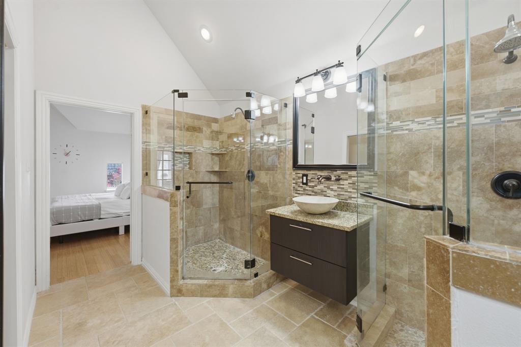 3315 Ricci Lane Irving, TX 75062 - Photo 28 of 40 Glass-enclosed shower with stone tile surround, mosaic accent tile, and a rainfall shower head