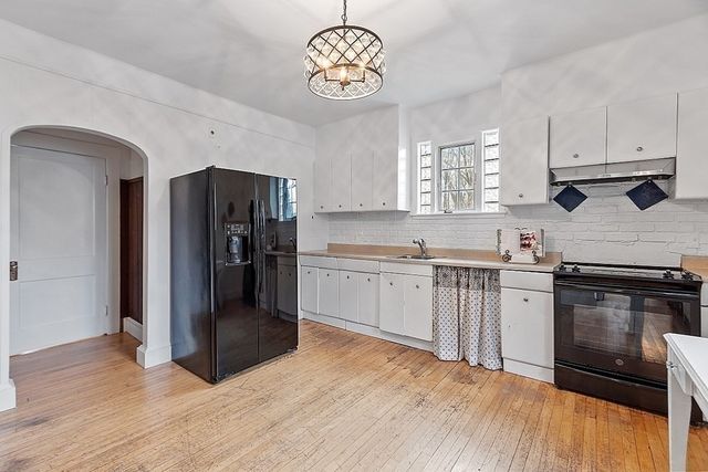 a kitchen with granite countertop a refrigerator stove top oven and sink