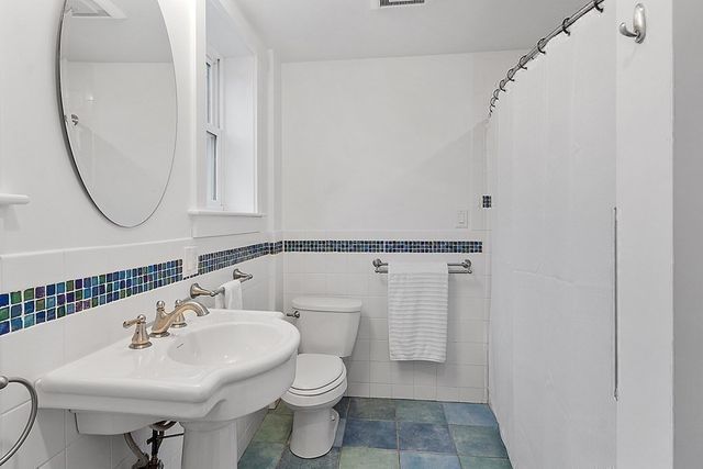 a bathroom with a sink a toilet and a mirror