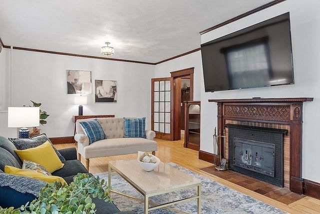 a living room with furniture a flat screen tv and a fireplace