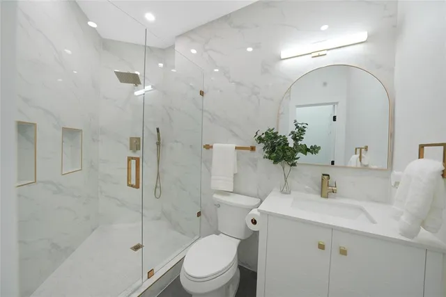 a bathroom with a sink and mirror with toilet