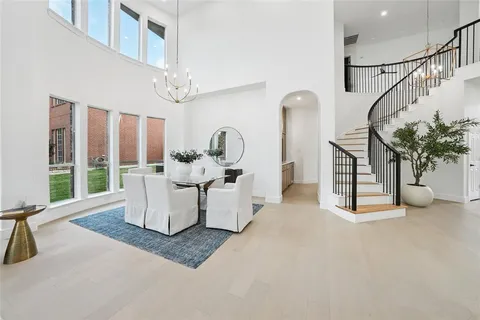 a living room with furniture a chandelier and a large window