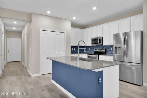 a kitchen with kitchen island a refrigerator sink and stove