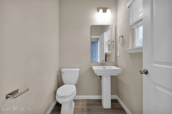 a bathroom with a toilet sink and mirror
