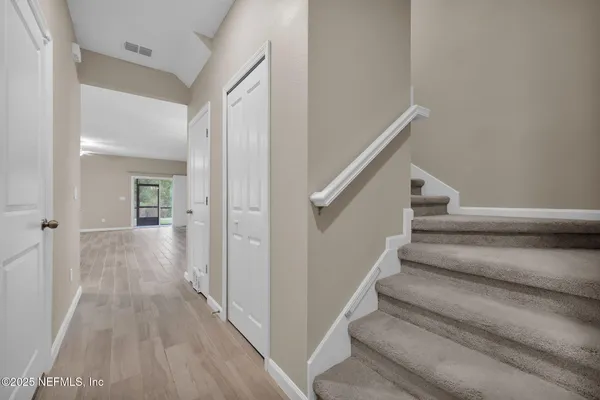 a view of a hallway with wooden floor and entryway