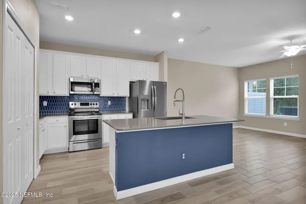 a kitchen with stainless steel appliances granite countertop a stove a sink and a refrigerator