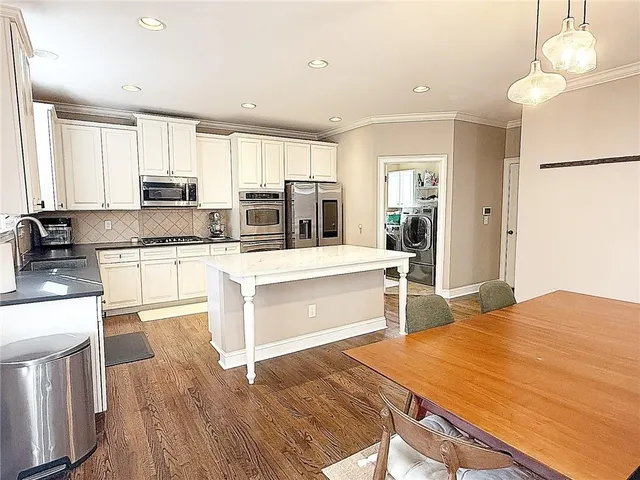a large kitchen with kitchen island a sink a stove a center island and a window