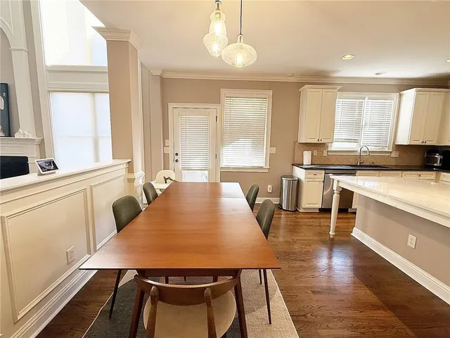 a large kitchen with a table chairs and flat screen tv