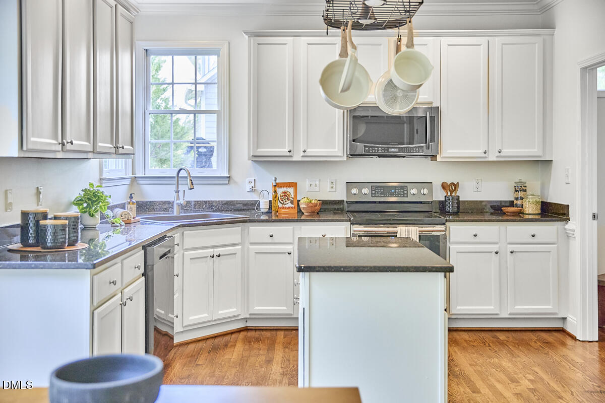 8030 Sundance Circle Durham, NC 27713 - Photo 29 of 61 a kitchen with stainless steel appliances granite countertop a sink a stove a microwave a counter space and cabinets