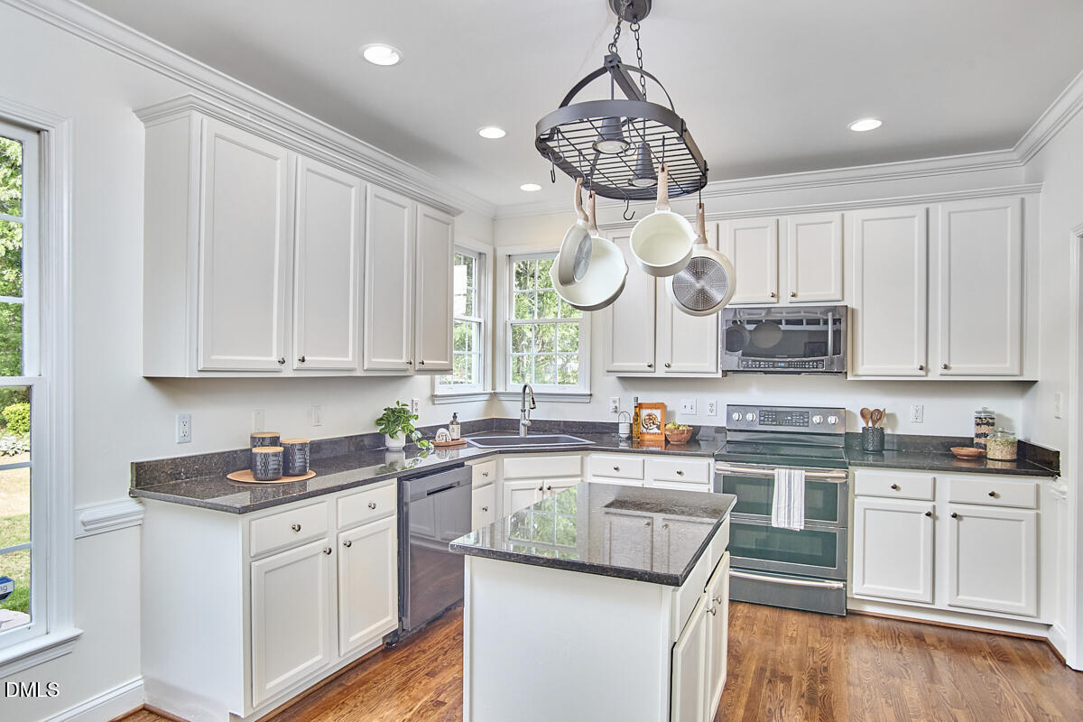 8030 Sundance Circle Durham, NC 27713 - Photo 30 of 61 a kitchen with stainless steel appliances granite countertop a sink a stove and cabinets