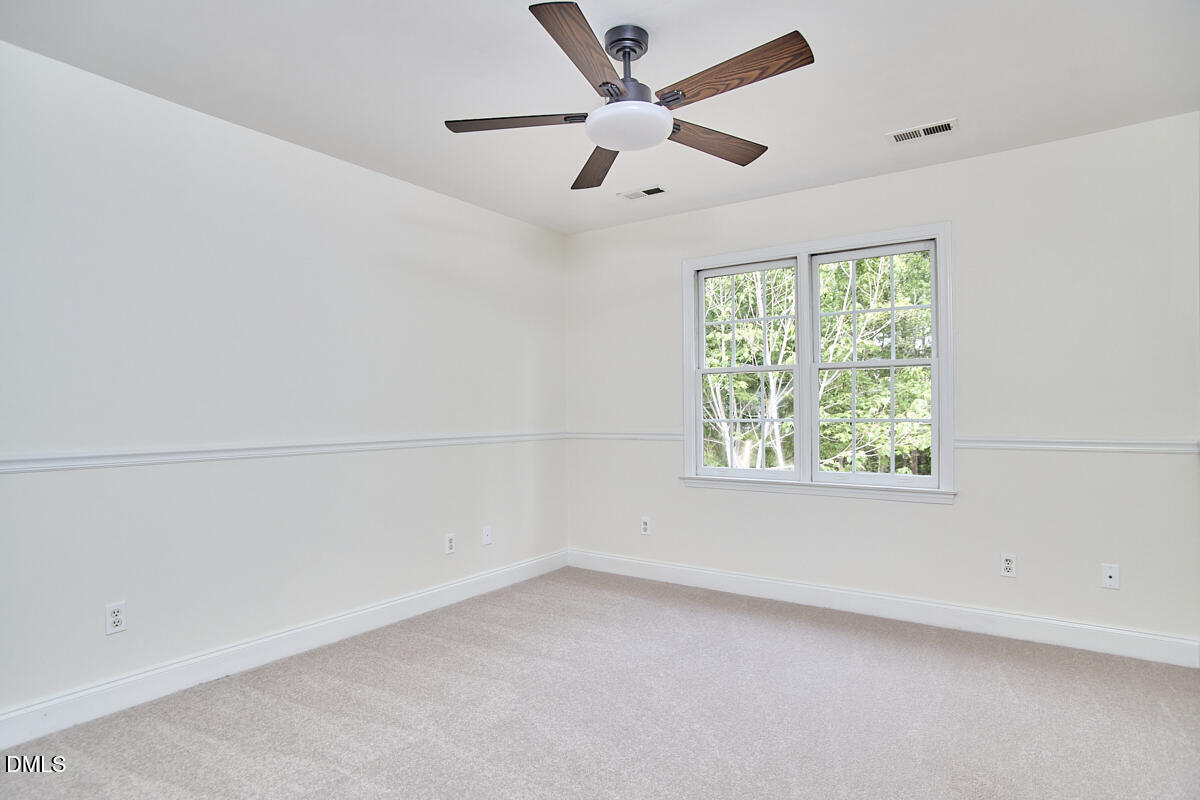 8030 Sundance Circle Durham, NC 27713 - Photo 35 of 61 an empty room with a ceiling fan and a large window