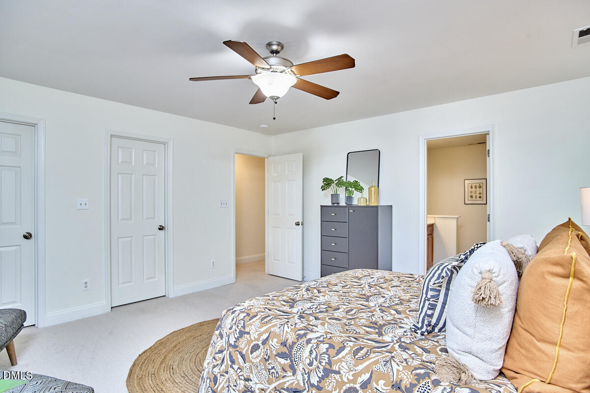 8030 Sundance Circle Durham, NC 27713 - Photo 39 of 61 a bedroom with a large bed and a chandelier
