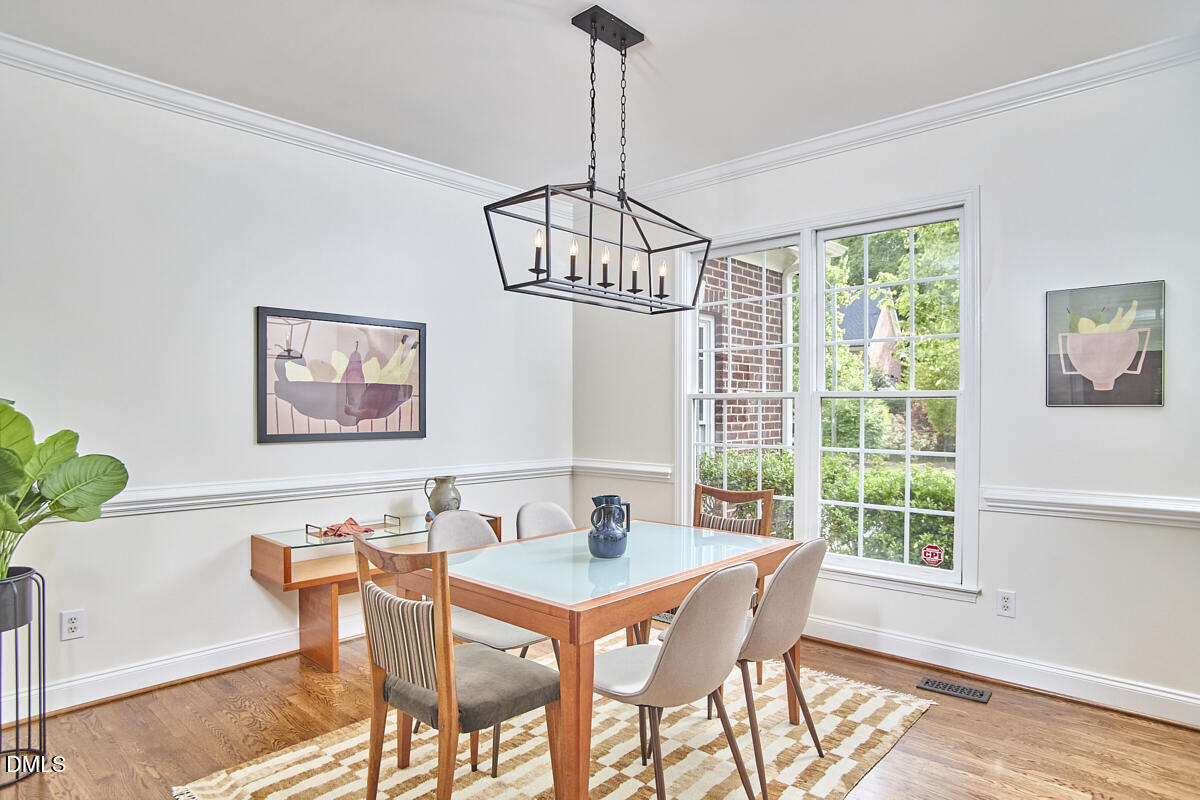 8030 Sundance Circle Durham, NC 27713 - Photo 9 of 61 a dining room with furniture a chandelier and wooden floor
