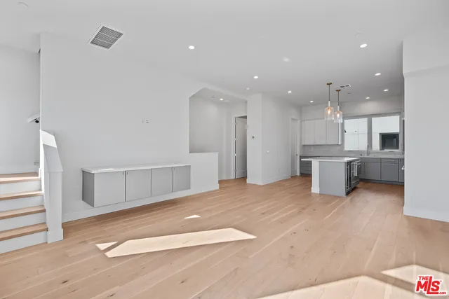 a view of kitchen with kitchen island wooden floor center island and appliances