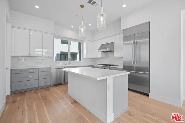 a kitchen with kitchen island white cabinets and stainless steel appliances