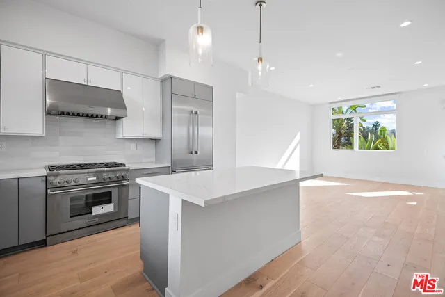 a kitchen with stainless steel appliances a stove a sink and a refrigerator