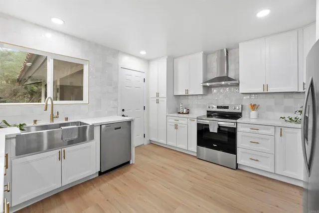 a kitchen with stainless steel appliances a table and chairs in it