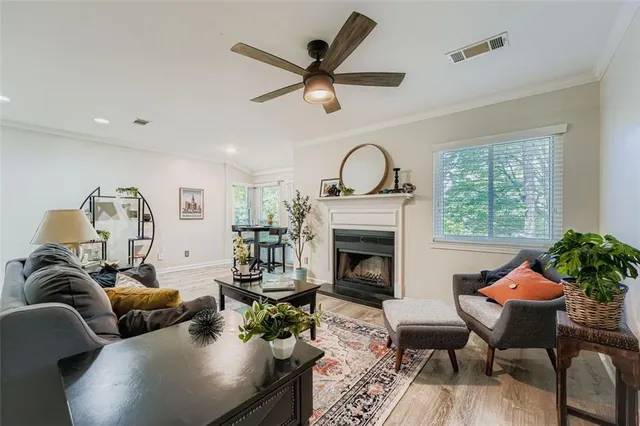 a living room with furniture a fireplace and a large window